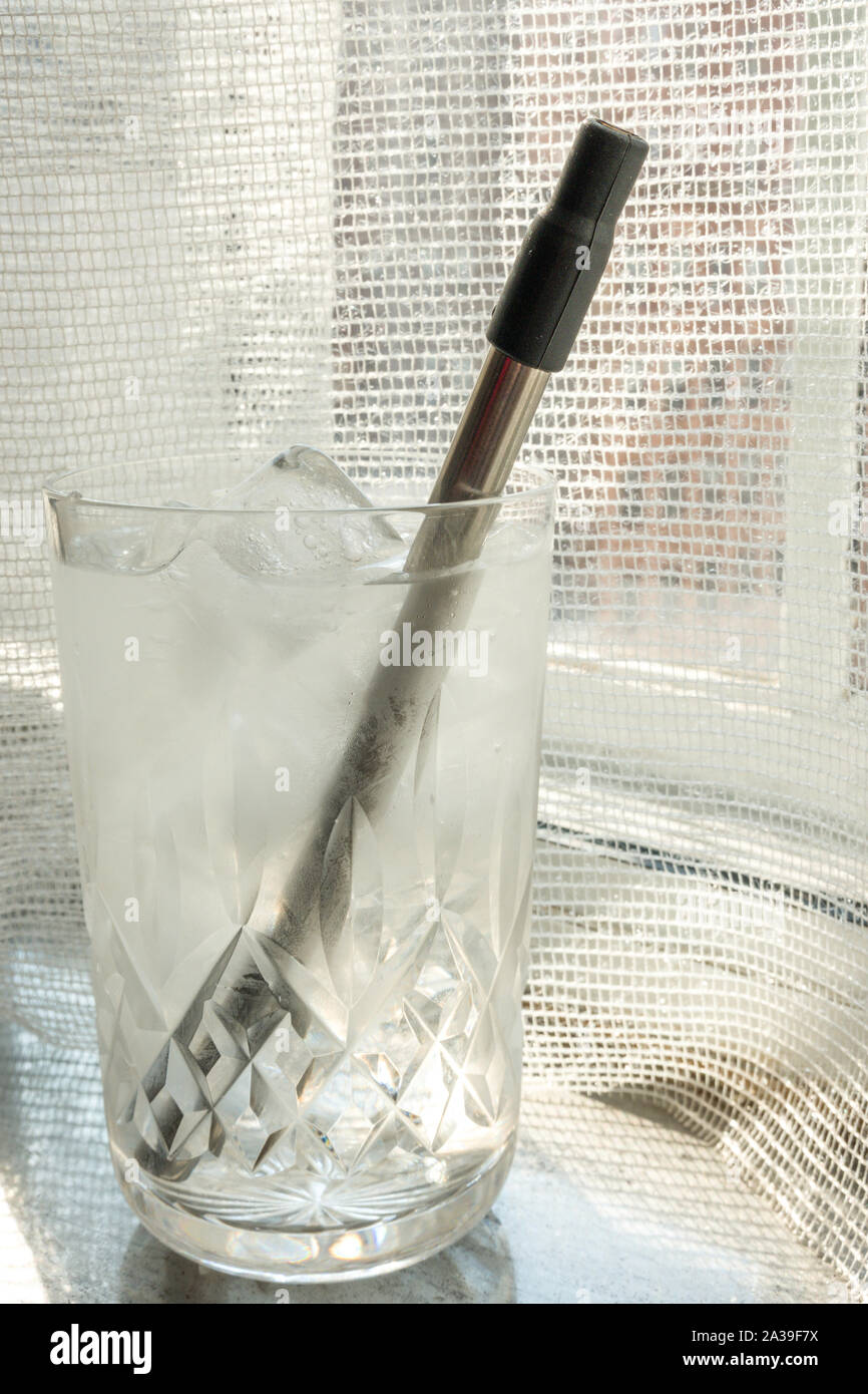 Riutilizzabili in plastica inox acciaio privo di paglia in uso in un bicchiere di acqua, STATI UNITI D'AMERICA Foto Stock