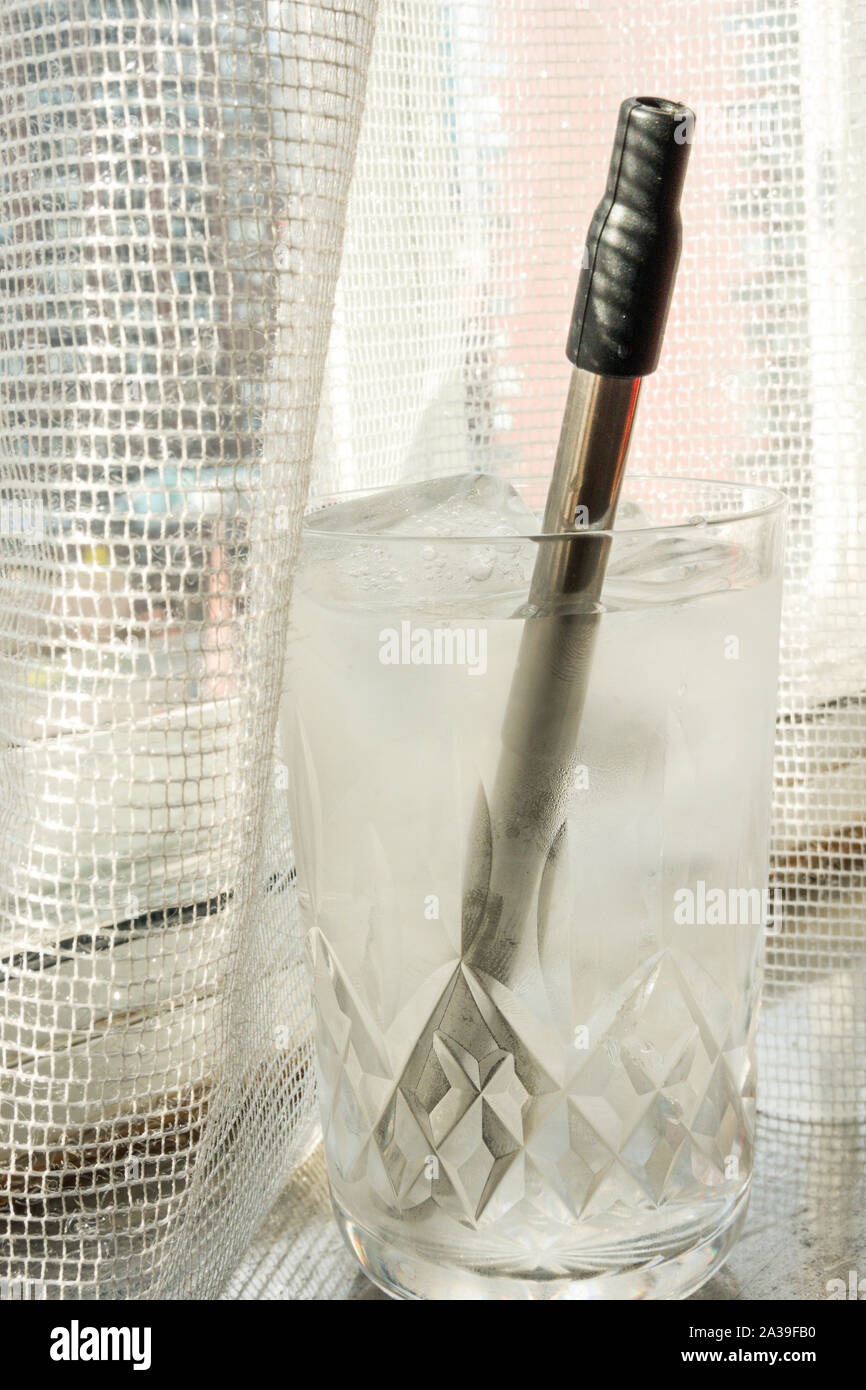 Riutilizzabili in plastica inox acciaio privo di paglia in uso in un bicchiere di acqua, STATI UNITI D'AMERICA Foto Stock