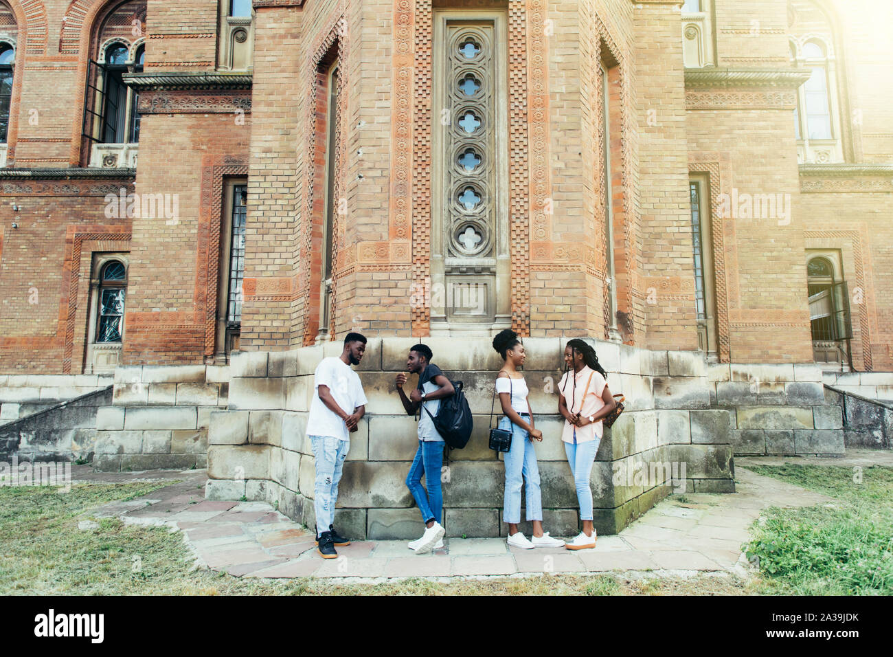 Il gruppo di allegro Allievi felici appoggiata sul muro bianco presso il campus. Internazionale il concetto di istruzione Foto Stock