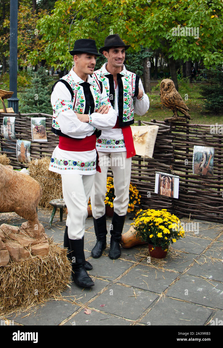 Chisinau in Moldova - Ottobre 5, 2019: due giovani uomini in un tradizionale costume dei Balcani a un festival a Chisinau e la capitale della Moldavia. Riposo nel parco Foto Stock