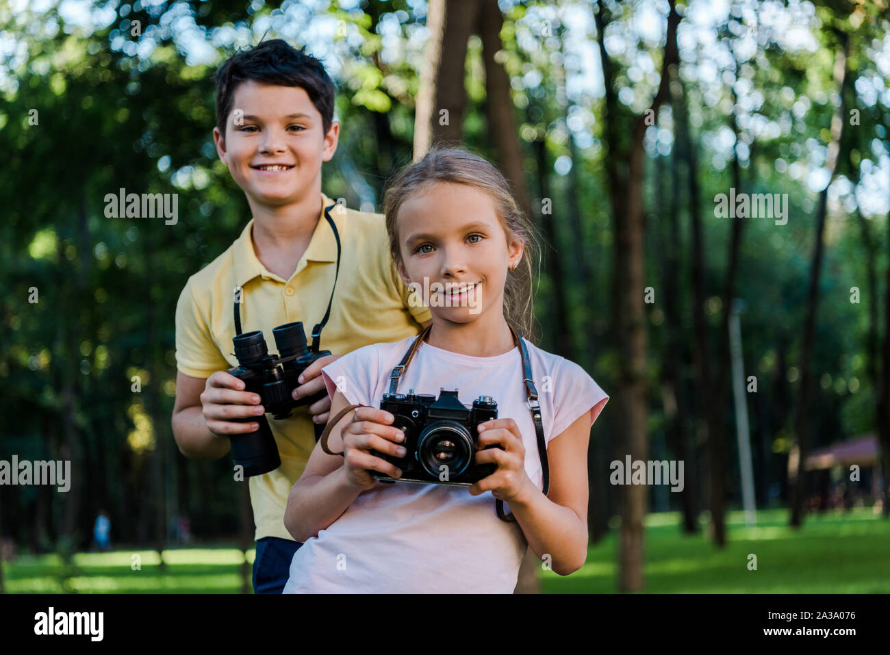Happy boy holding binocolo amico vicino con fotocamera digitale in  posizione di parcheggio Foto stock - Alamy