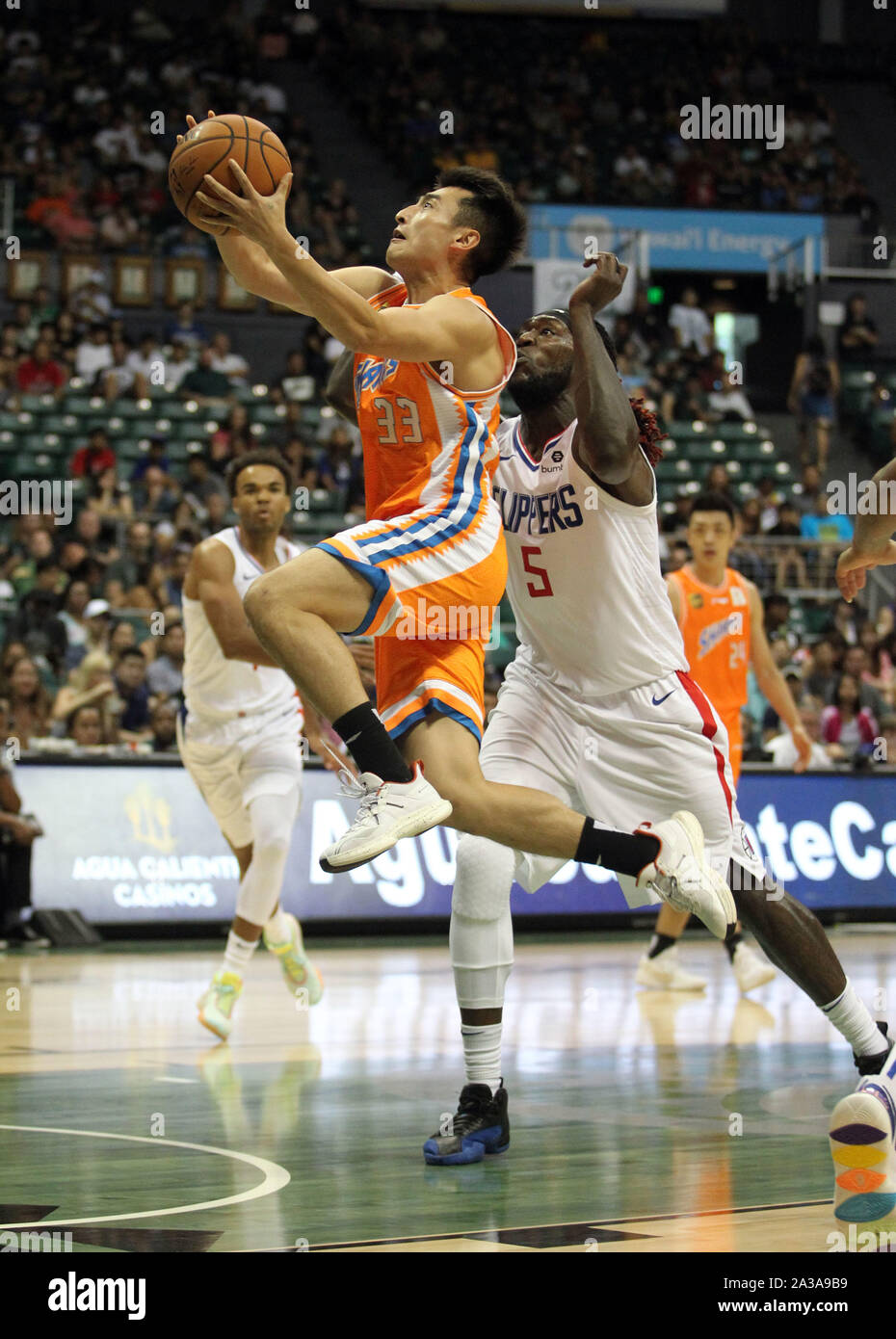 Honolulu, Hawaii. 6 Ottobre 2019 - Shanghai squali guard Luo Hanchen #33 aziona passato Los Angeles Clippers avanti Montrezl Harrell #5 per il cerchio durante una partita di preseason tra i Los Angeles Clippers e la Shanghai squali a Stan Sheriff centro sul campus della University of Hawaii a manoa a Honolulu, HI - Michael Sullivan/CSM. Foto Stock