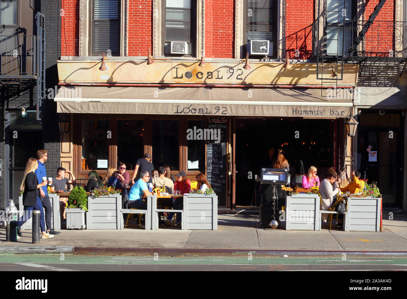 Enti locali 92, 92 2° Avenue, New York, NY. esterno alla vetrina di un ristorante e cafè sul marciapiede in East Village quartiere di Manhattan. Foto Stock