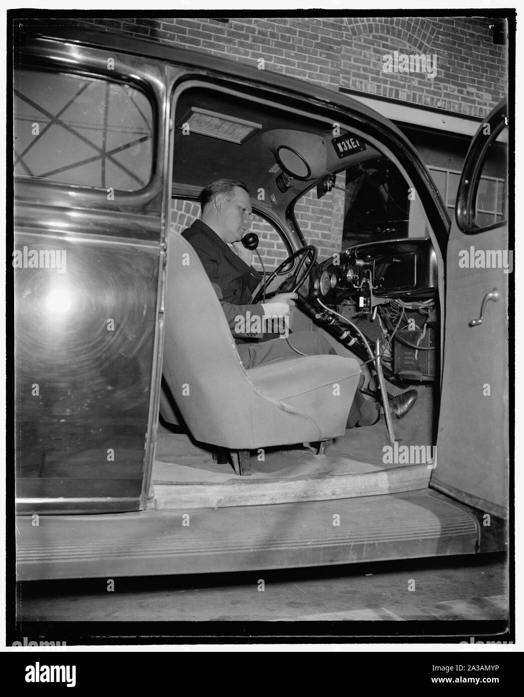 Il sergente Frank M. Beall, responsabile della stazione, seduti nella parte sperimentale 2 vie di comunicazione car. Egli è la rimozione del trasmettitore per telefono per effettuare una chiamata, 10/38 Foto Stock