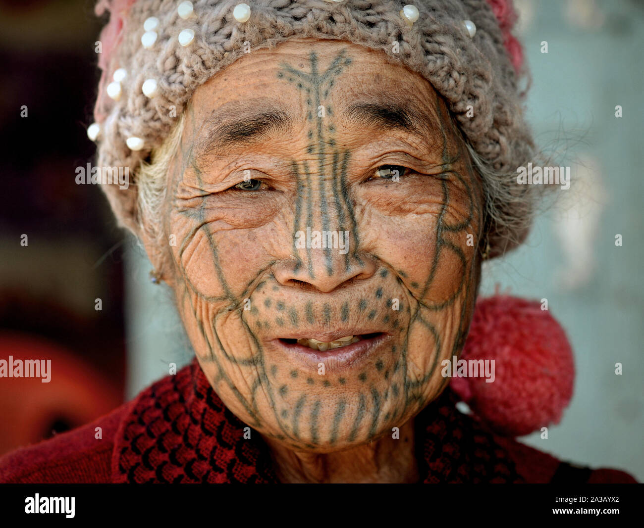 Anziani mento Muun hill-tribe donna ('sdonna ragno') con un tradizionale tatuaggi facciali pone per la fotocamera. Foto Stock