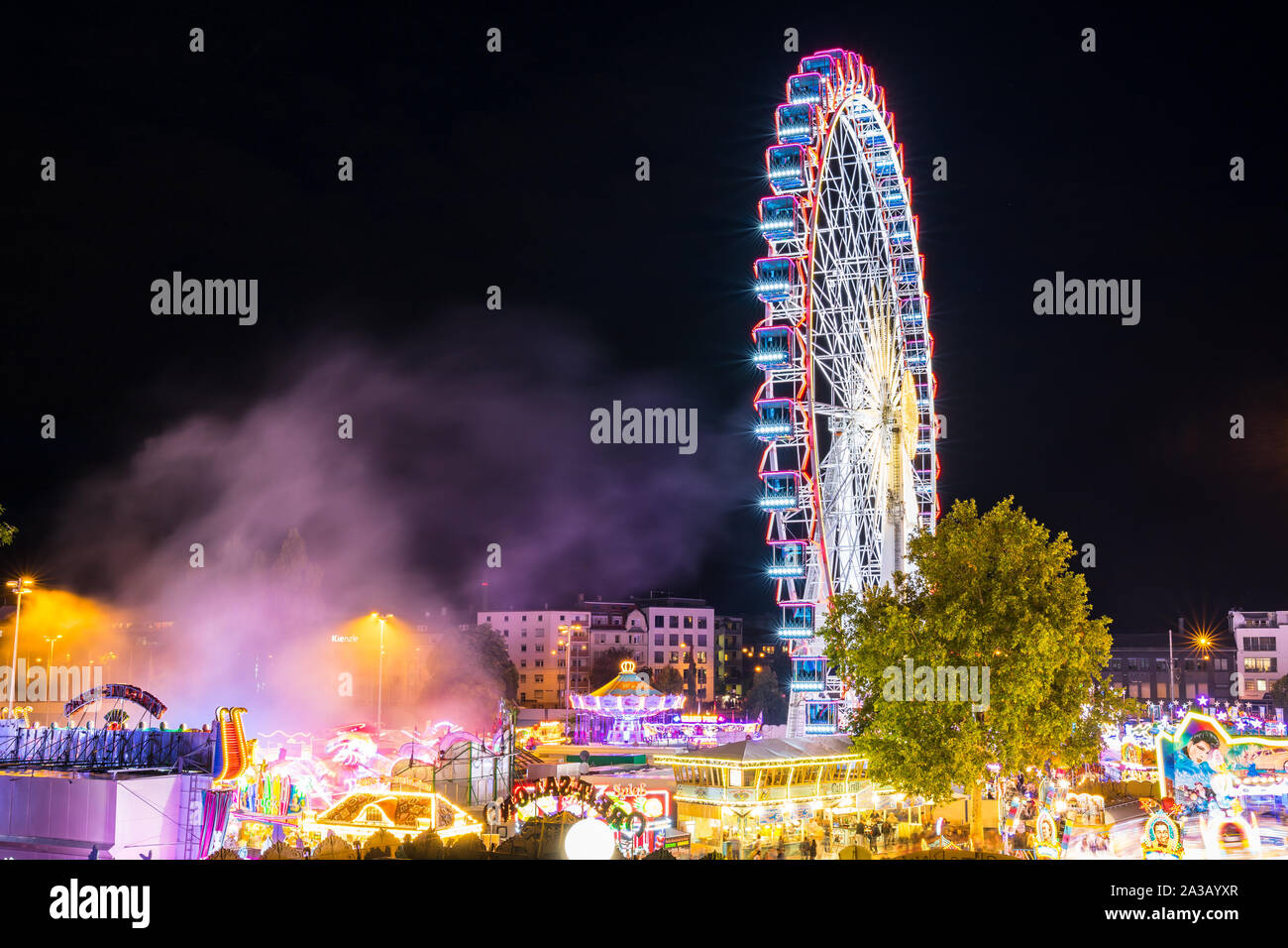 Stoccarda, Germania, 3 ottobre 2019, Canstatter wasen oktoberfest, una fiera illuminata di notte con molti giostra ruota grande e cibo offerte a Bad ca Foto Stock