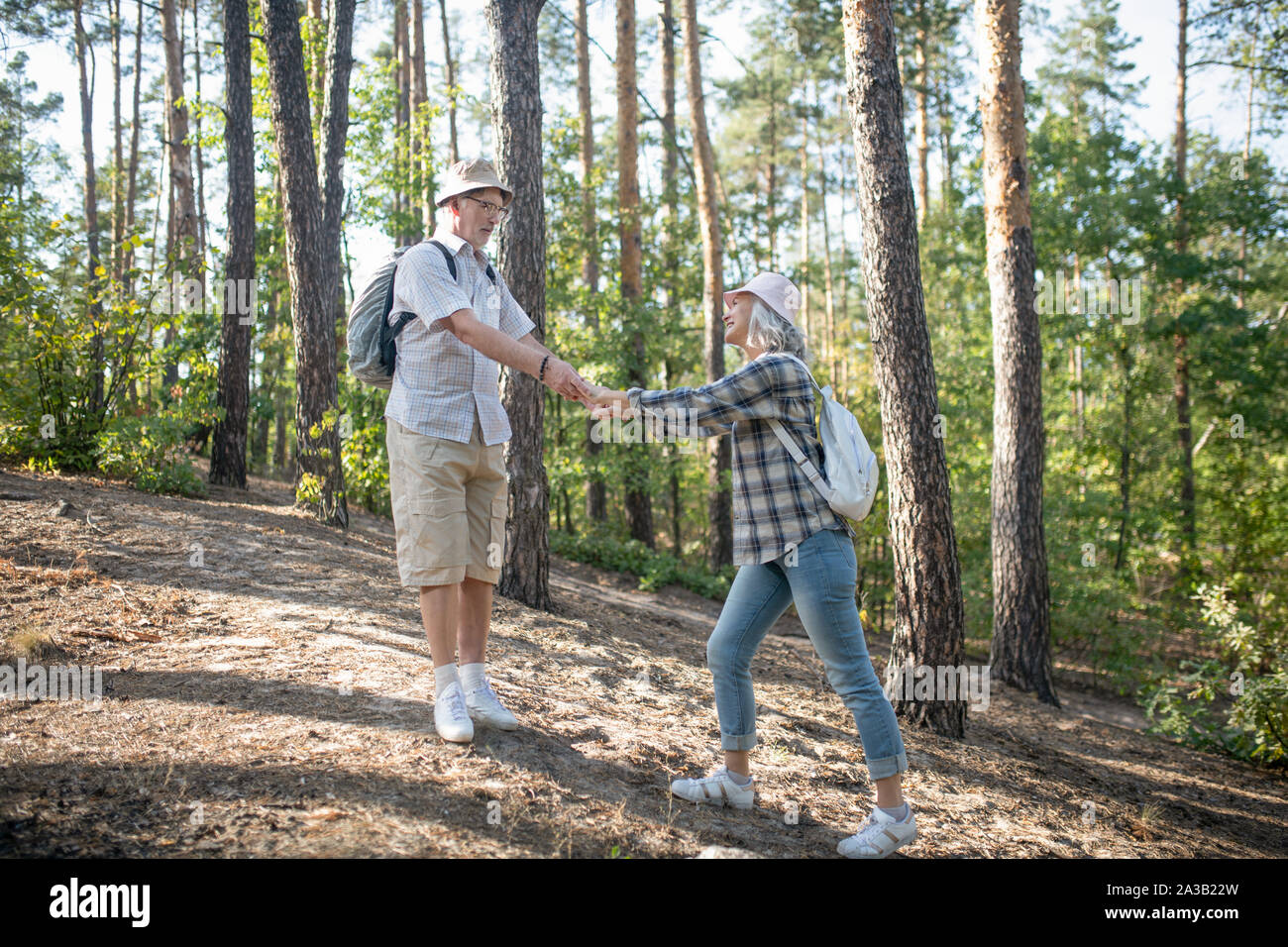 Coppia di adulti maturi che indossa zaini passeggiate in foresta Foto Stock