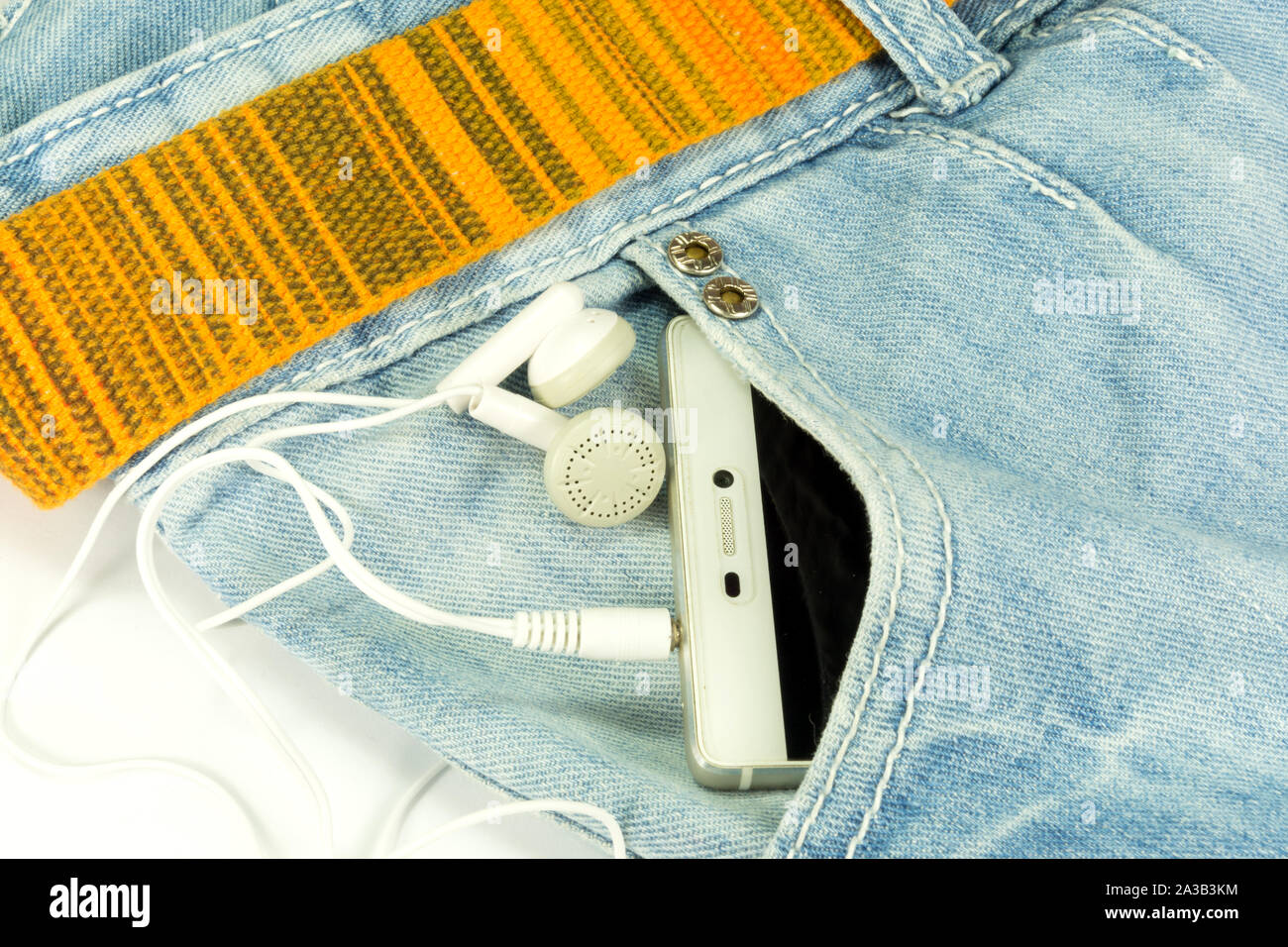 Smartphone e le cuffie nella tasca dei pantaloni Foto Stock