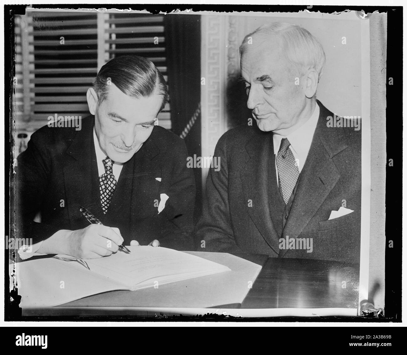 Firmare accordi commerciali. Washington, gli Stati Uniti e la Cecoslovacchia hanno firmato oggi un accordo commerciale destinato a mantenere e a migliorare i benefici reciprocamente le relazioni commerciali tra i due paesi. La foto mostra il Segretario di Stato Cordell Hull, che ha firmato per gli Stati Uniti (a destra) come ha guardato il ministro cecoslovacco Vladimir Hurban firmare il documento Foto Stock