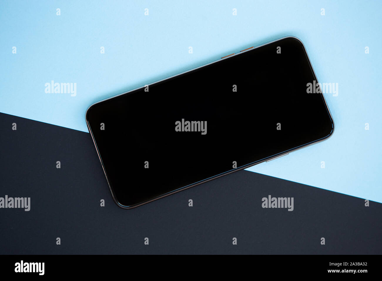Telefono cellulare con schermo chiaro in flat lay.nuovo smartphone con grande touchscreen nero.Posizionare il logo di applicazione su uno spazio vuoto. Foto Stock