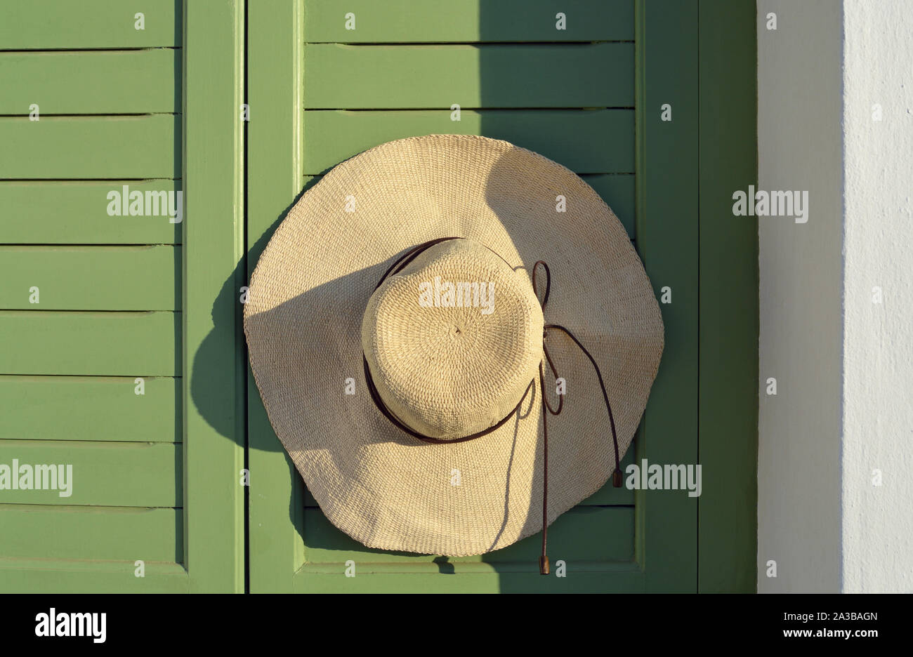 Cappello di paglia appeso sulla porta di legno Foto stock - Alamy
