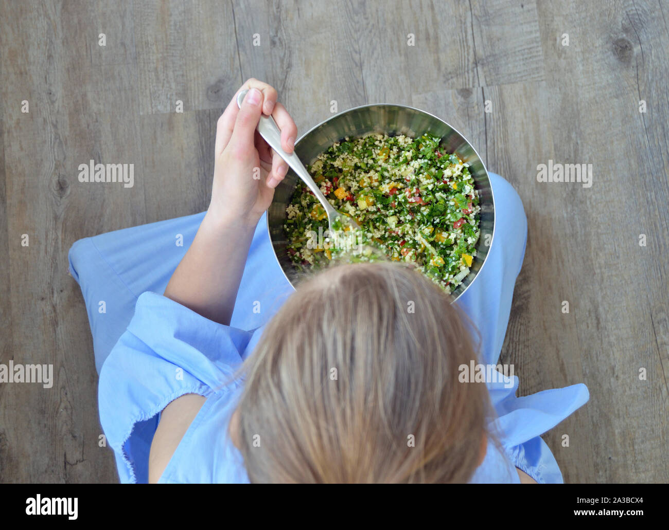 Alta angolazione della ragazza di mangiare da una ciotola di insalata Foto Stock