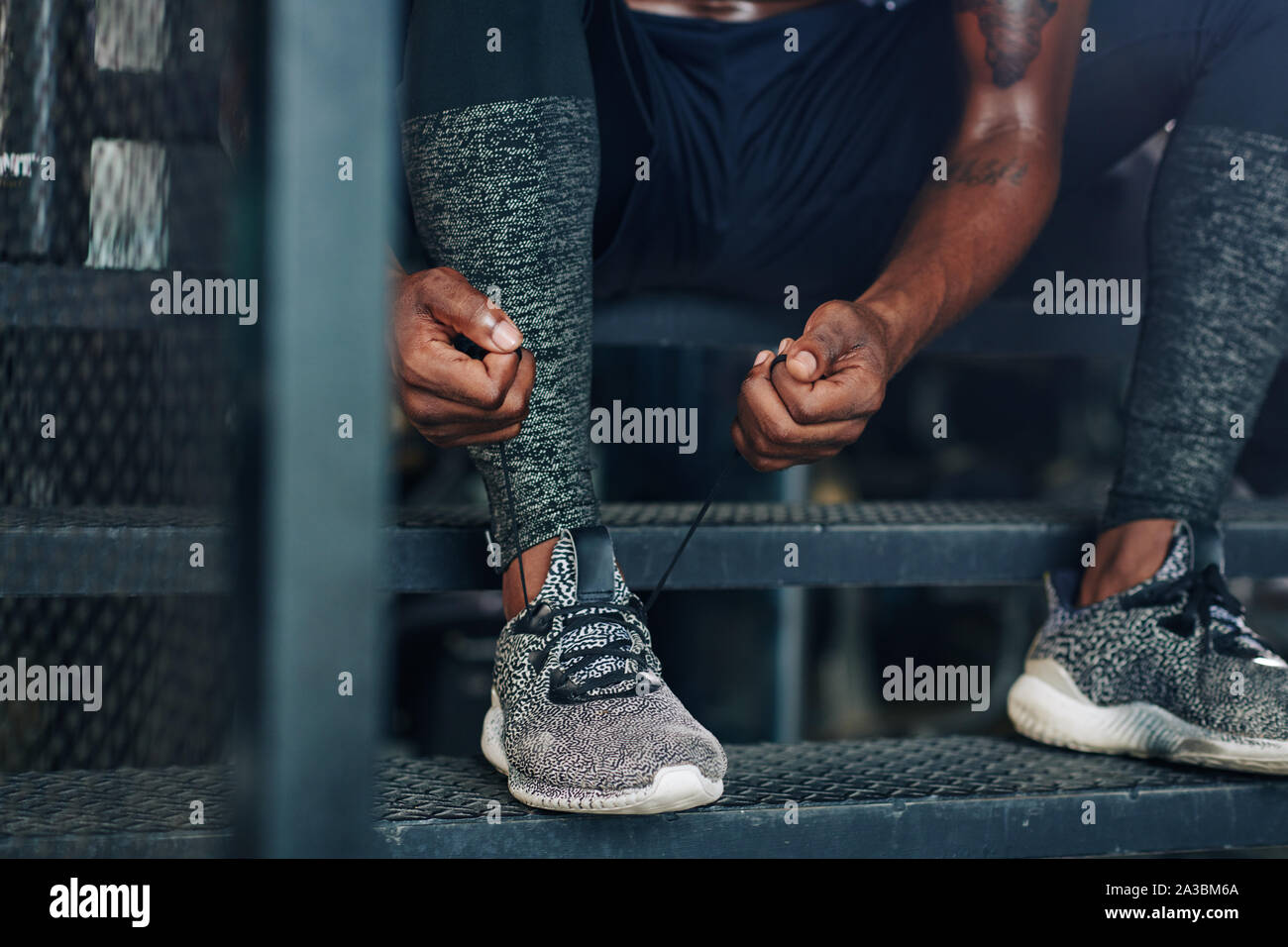 Close-up immagine dell'atleta lacci di legatura della sua palestra scarpe prima della formazione in palestra Foto Stock