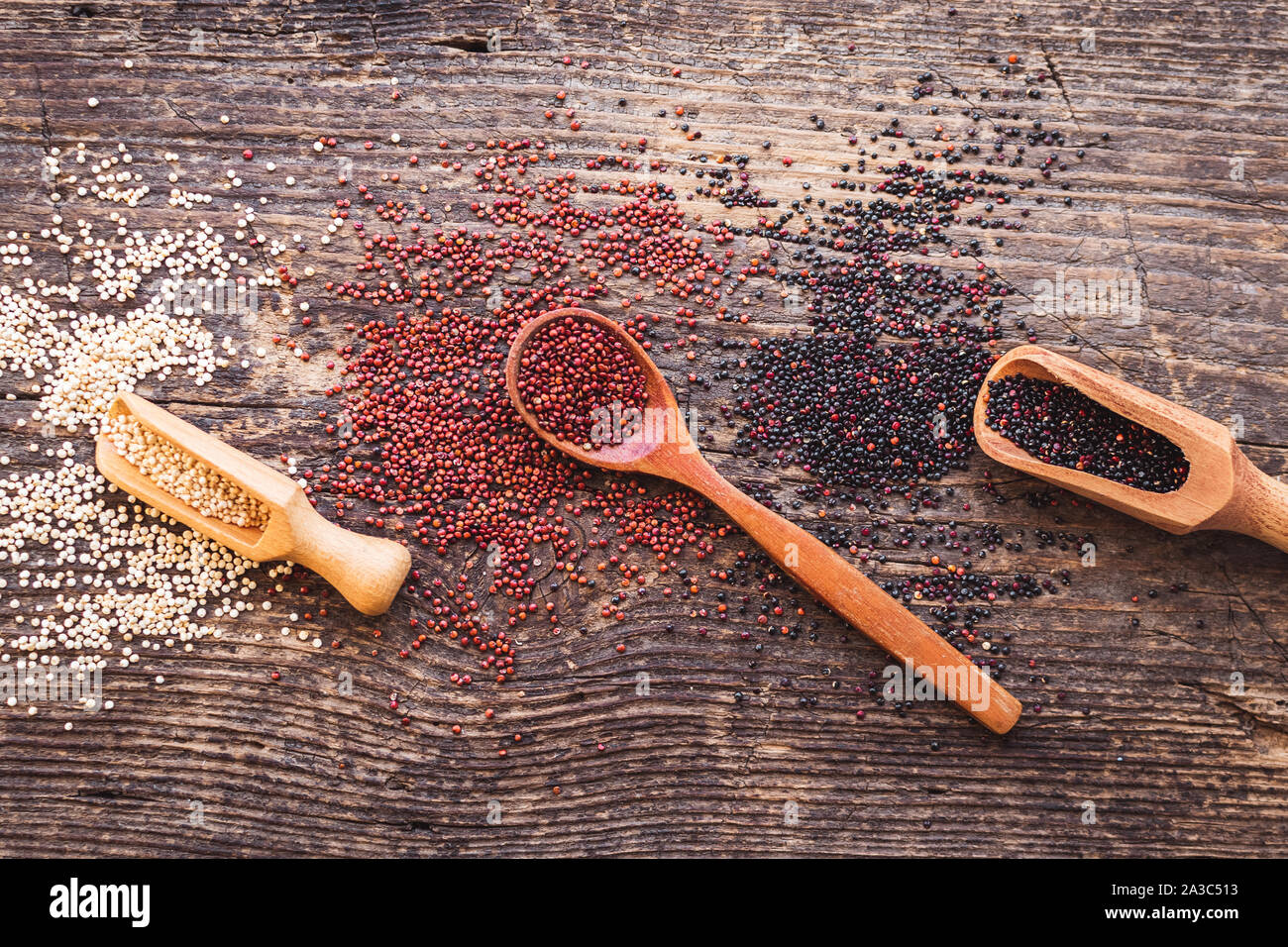 Nero, rosso e bianco di quinoa grani su sfondo di legno. Cibo sano. Vista dall'alto. Foto Stock