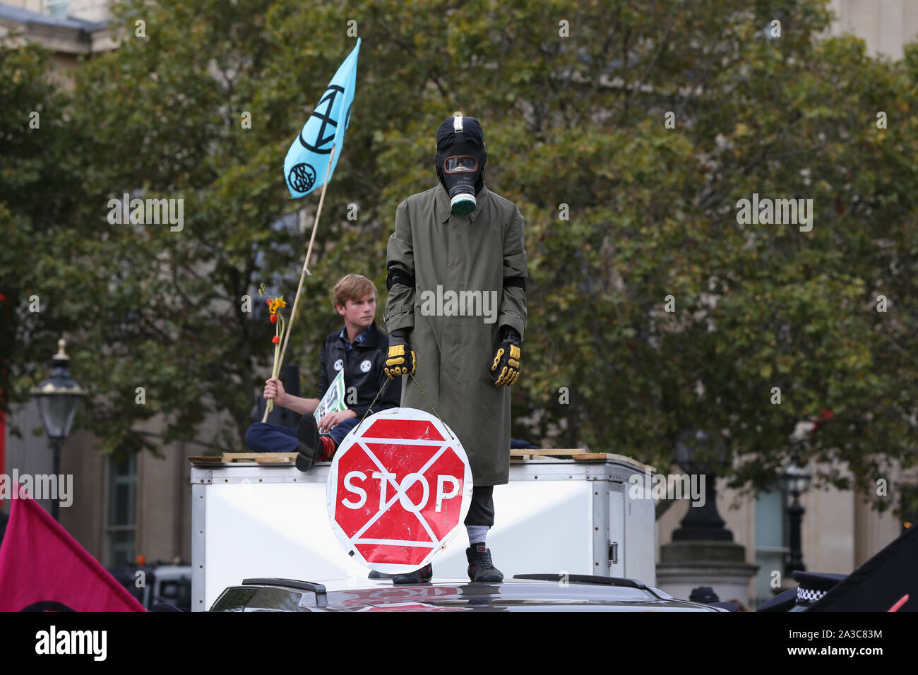 I manifestanti sulla parte superiore dei veicoli bloccando la strada in Trafalgar Square durante la ribellione di estinzione protesta di Londra. Foto Stock