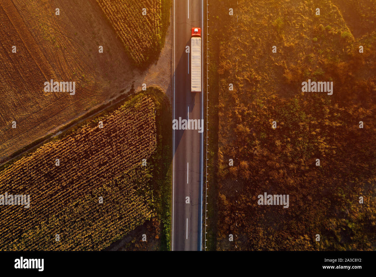 Carrello sulla strada nel tramonto, vista dall'alto del singolo veicolo di trasporto con rimorchio da fuco pov Foto Stock