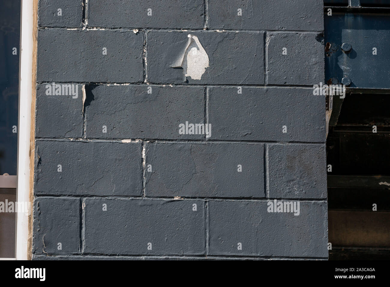 La vernice nera la pelatura del lato di un edificio Foto Stock