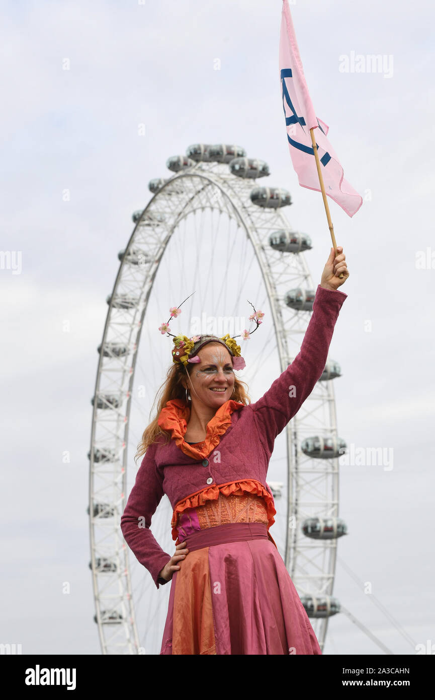 Un protestor sventola una bandiera durante una ribellione di estinzione protesta in Westminster, Londra. Foto Stock