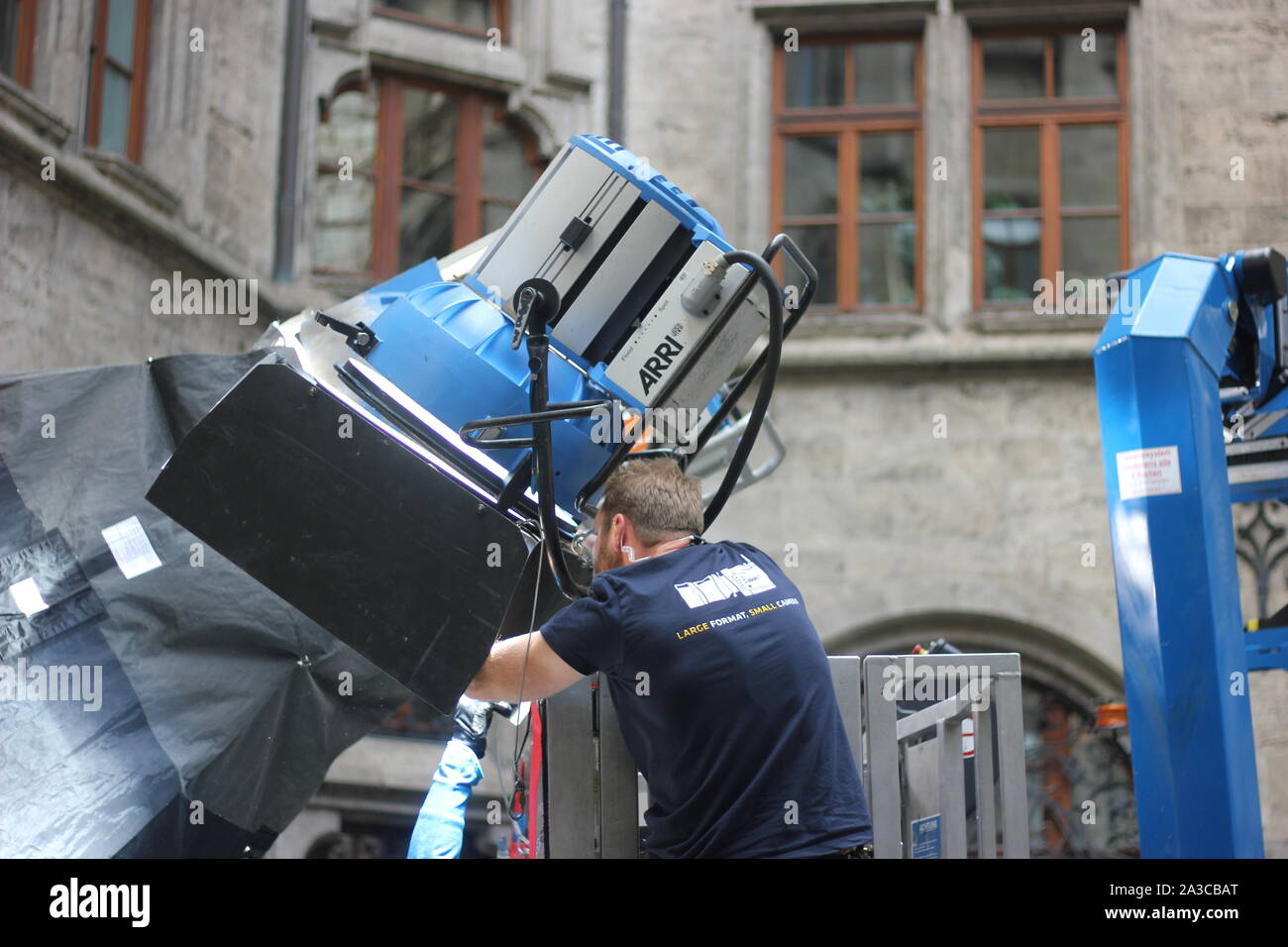 Illuminatore a lavorare con grande faro anteriore per riprese di film. Foto Stock