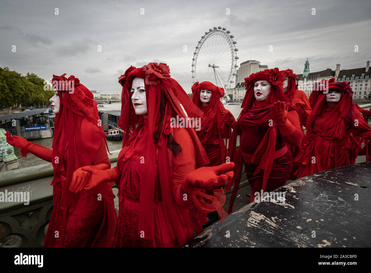 Londra, Regno Unito. Il 7 ottobre, 2019. Estinzione Rebellion 'Rosso brigata di ribelli' arrivano a Westminster nel loro marchio rosso sangue outfits per unirsi alla protesta. Il attivisti ambientali iniziare una nuova ondata di azione di protesta questa mattina causando interruzioni presso i siti principali di Londra. Credito: Guy Corbishley/Alamy Live News Foto Stock