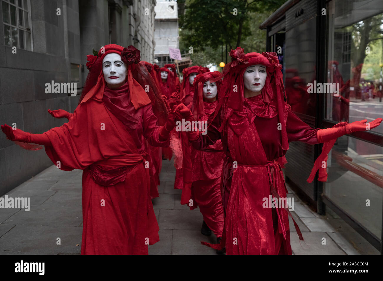 Londra, Regno Unito. Il 7 ottobre, 2019. Estinzione Rebellion 'Rosso brigata di ribelli' arrivano a Westminster nel loro marchio rosso sangue outfits per unirsi alla protesta. Il attivisti ambientali iniziare una nuova ondata di azione di protesta questa mattina causando interruzioni presso i siti principali di Londra. Credito: Guy Corbishley/Alamy Live News Foto Stock