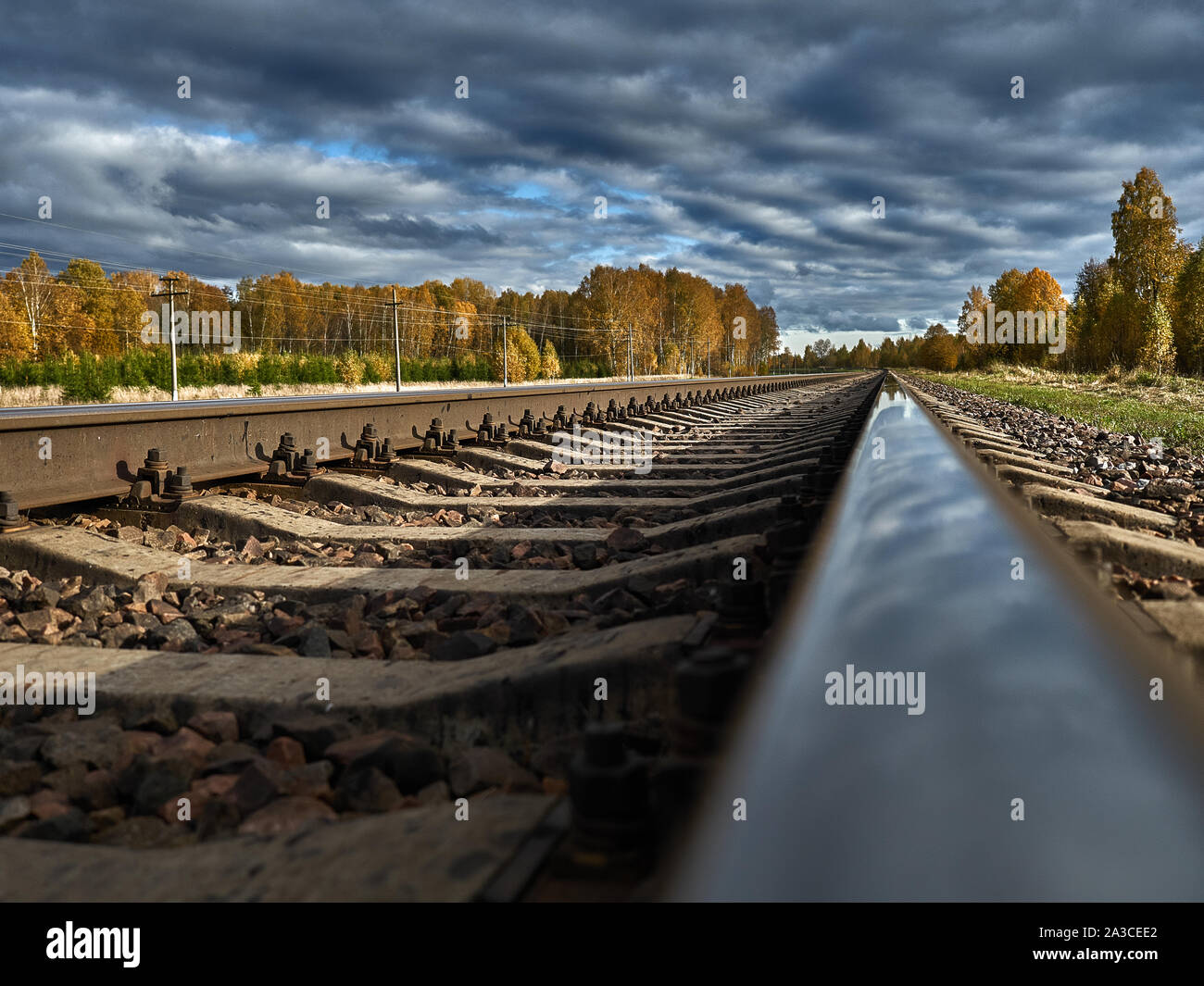 La strada ferrata contro lo sfondo di un azzurro cielo di autunno va all'infinito. Foto Stock