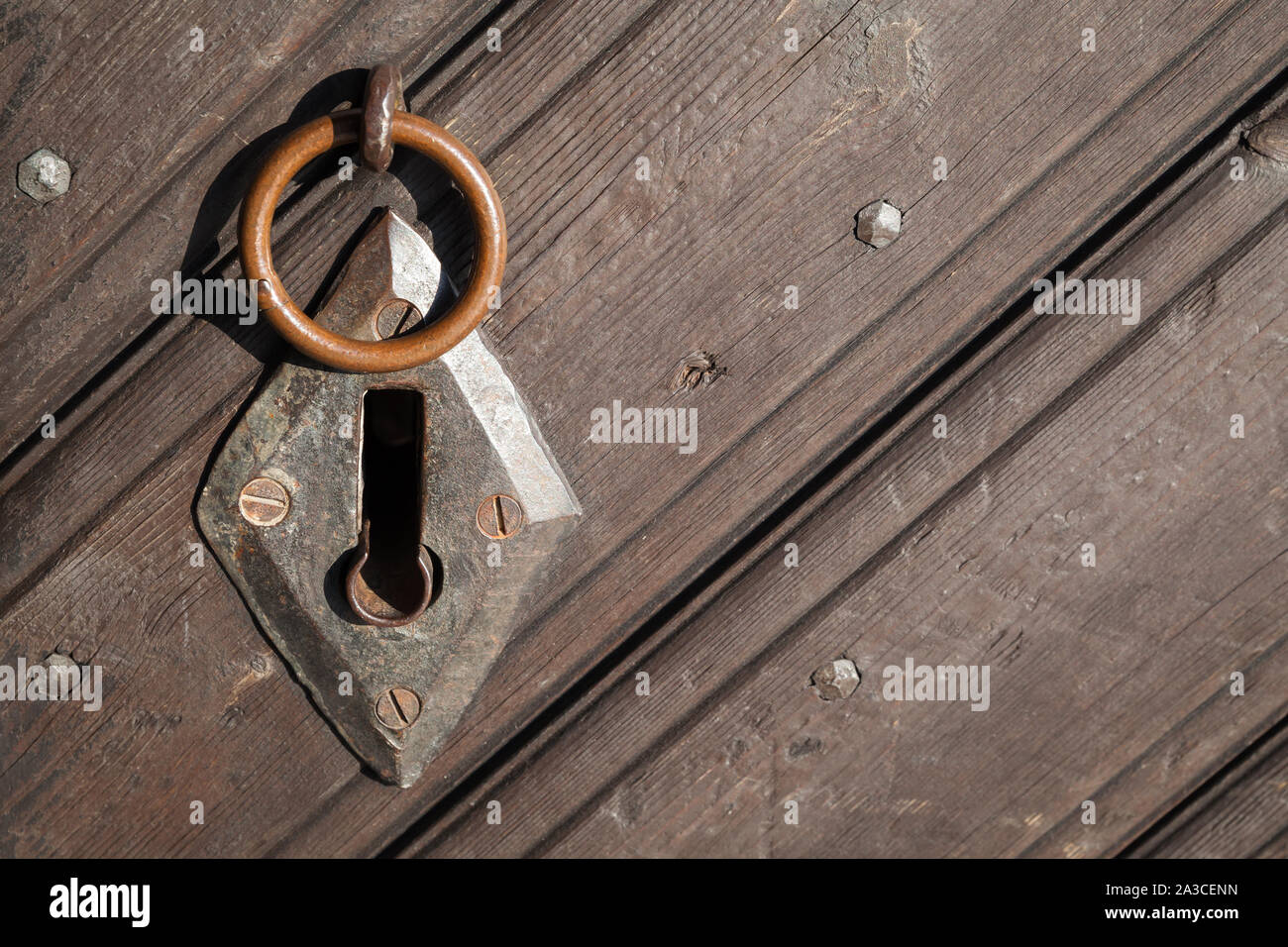 Vecchio arrugginito keyhole e piccolo anello sulla porta di legno, close-up foto Foto Stock