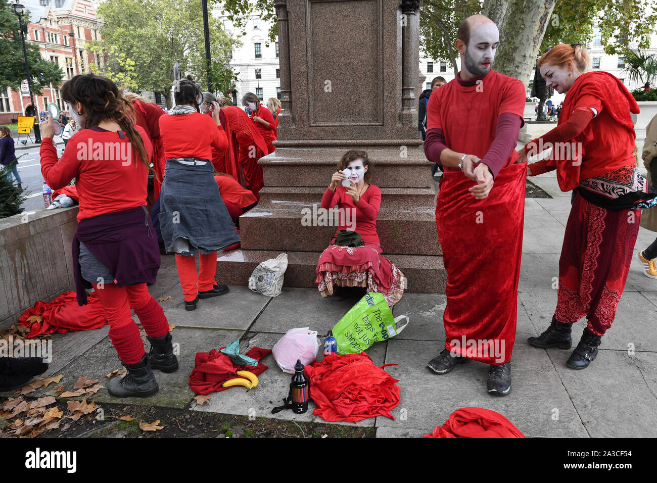 Membri del 'Rosso Brigata" entrare in costume e applicare il make-up per un'estinzione della ribellione protesta in Westminster, Londra. Foto Stock