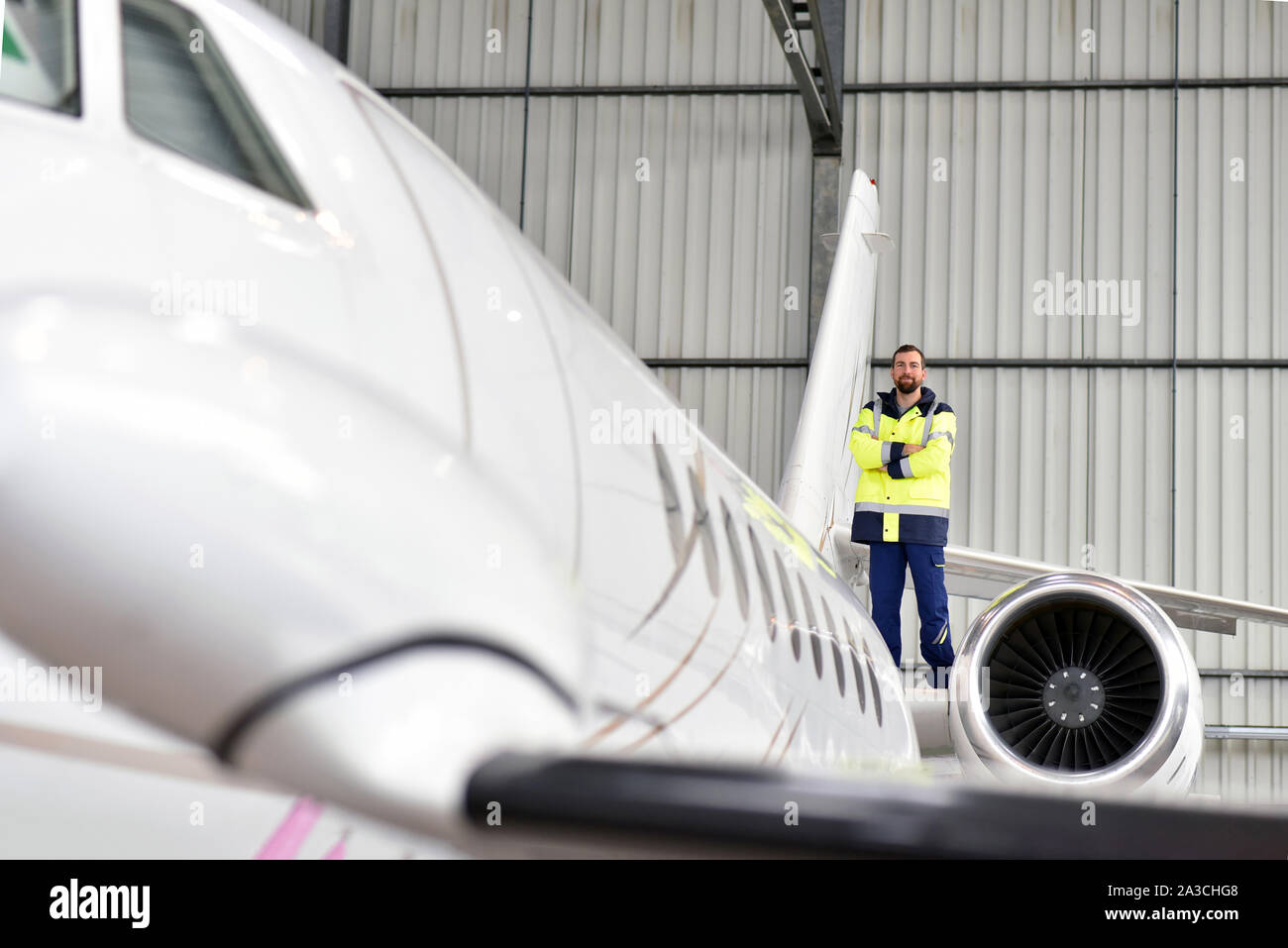 I lavoratori aeroportuali controllare un aereo per la sicurezza in un hangar Foto Stock