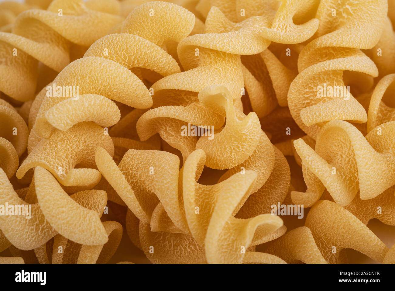 Fusilli italiano la pasta grezza sullo sfondo Foto Stock