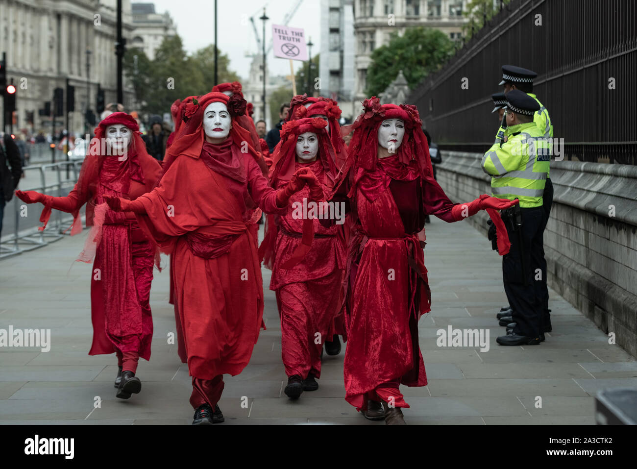Londra, Regno Unito. Il 7 ottobre, 2019. Estinzione Rebellion 'Rosso brigata di ribelli' arrivano a Westminster nel loro marchio rosso sangue outfits per unirsi alla protesta. Il attivisti ambientali iniziare una nuova ondata di azione di protesta questa mattina causando interruzioni presso i siti principali di Londra. Credito: Guy Corbishley/Alamy Live News Foto Stock