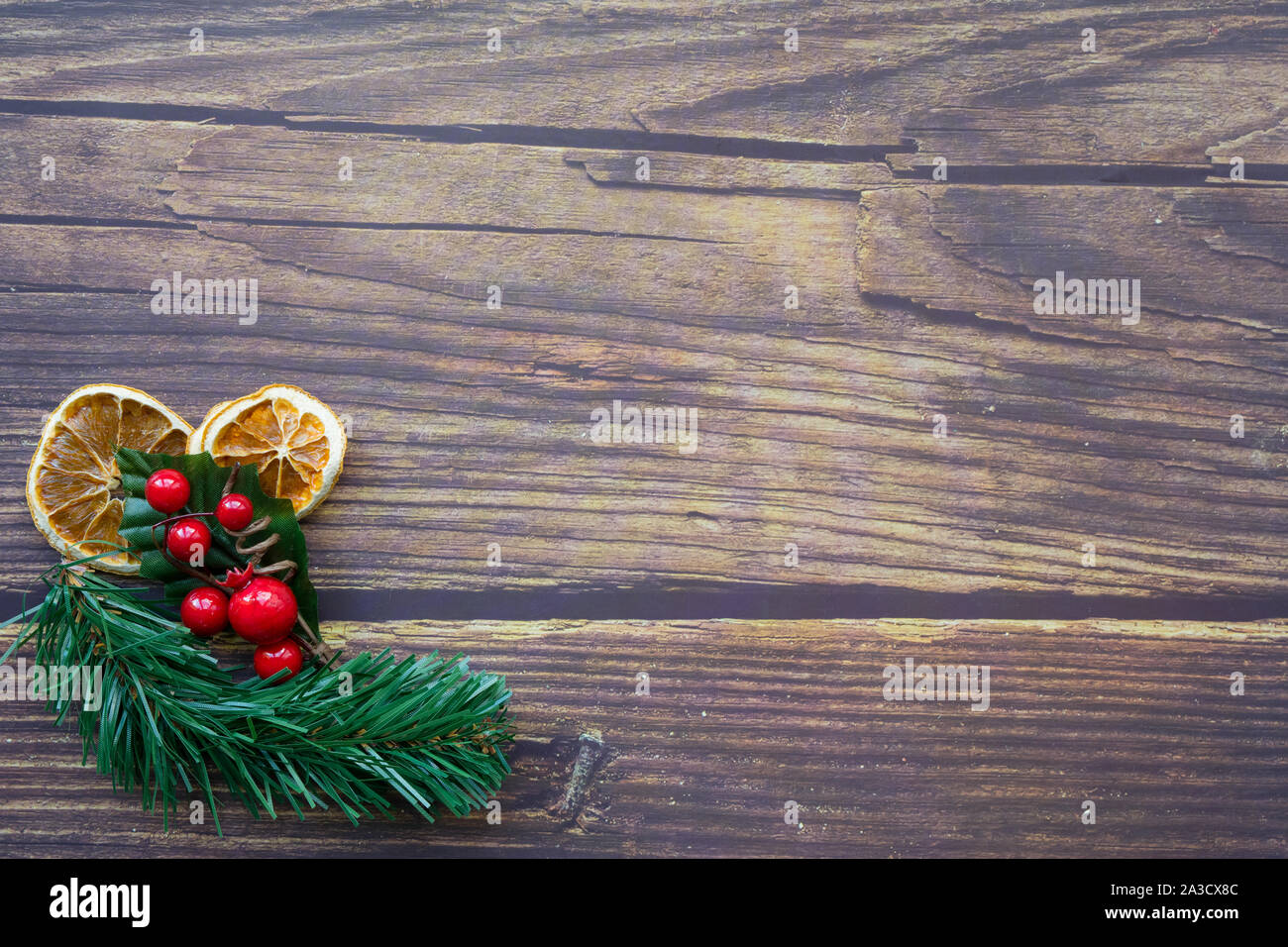 Sfondo di Natale da essiccato arance, ramoscello di pino e di elementi decorativi di bacche rosse su un tavolo di legno. Felice anno nuovo. Foto Stock