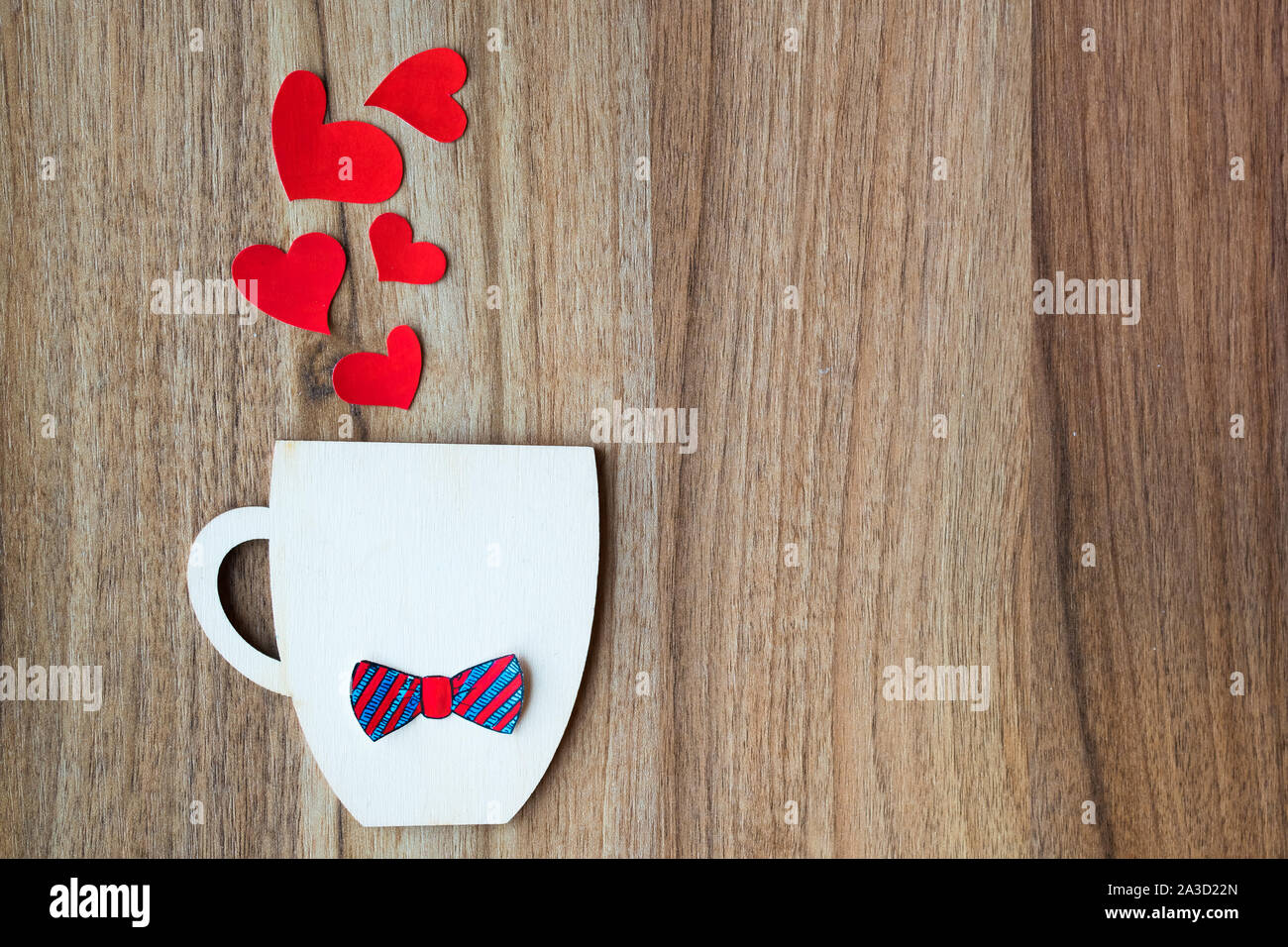 Padri giorno concetto. Coppa decorativa con carta filtro bow tie e cuori rossi su sfondo di legno. Copyspace. Foto Stock