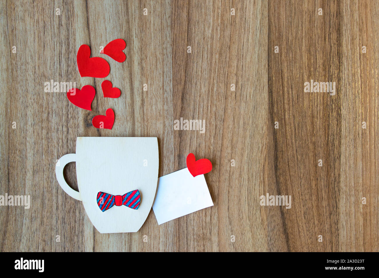 Padri giorno concetto. Coppa decorativa con carta filtro bow tie e cuori su sfondo di legno. Copyspace. Foto Stock