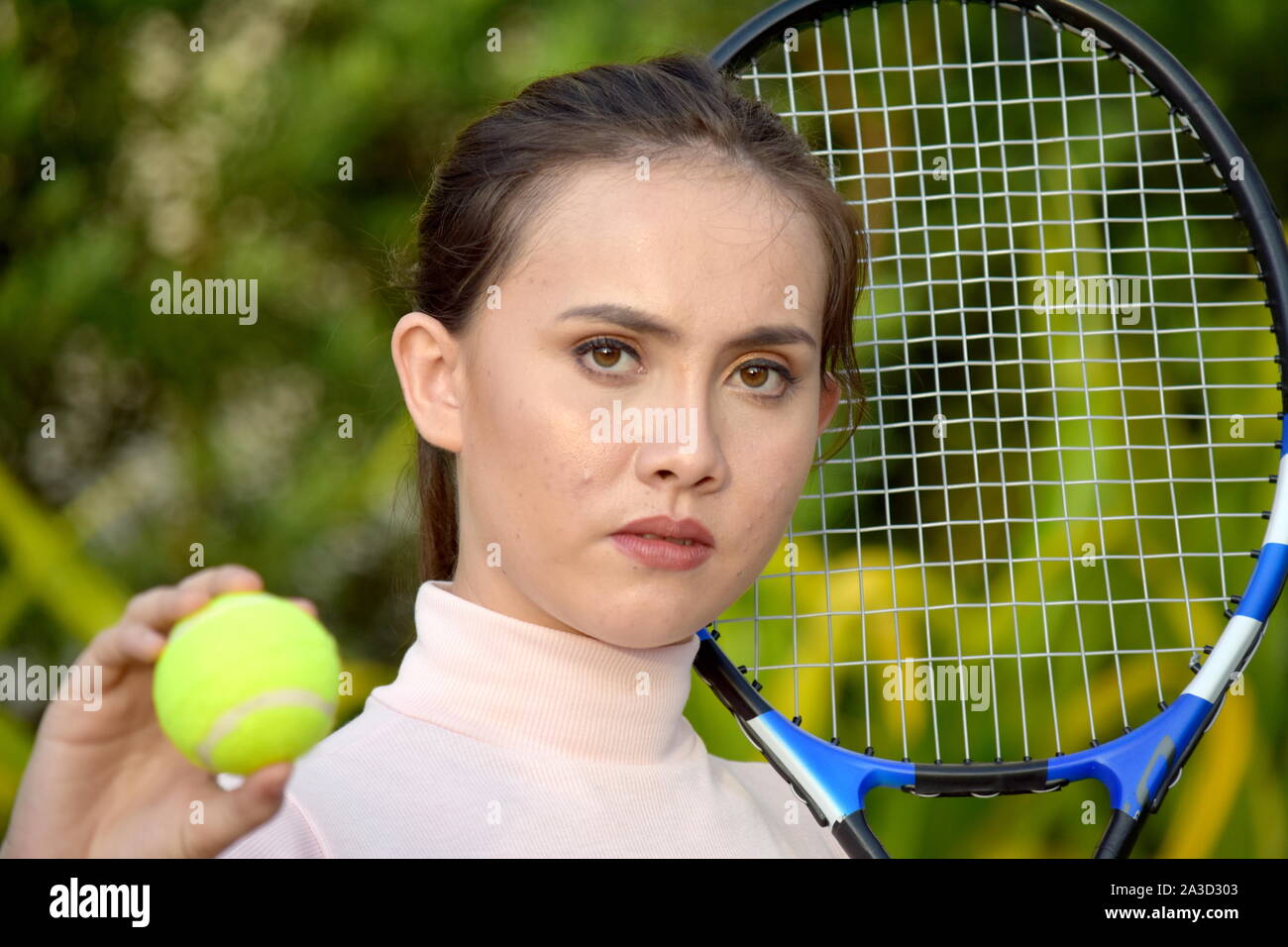 Impassibile ragazza giocatore di tennis con la racchetta da tennis Foto Stock