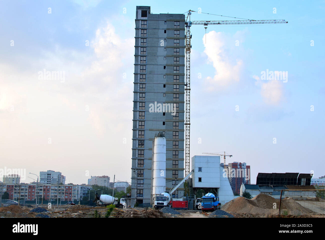 Calcestruzzo cellulare impianto di dosaggio sul sito di costruzione sullo sfondo di una gru a torre e un multipiano di complesso residenziale in costruzione - Foto Stock