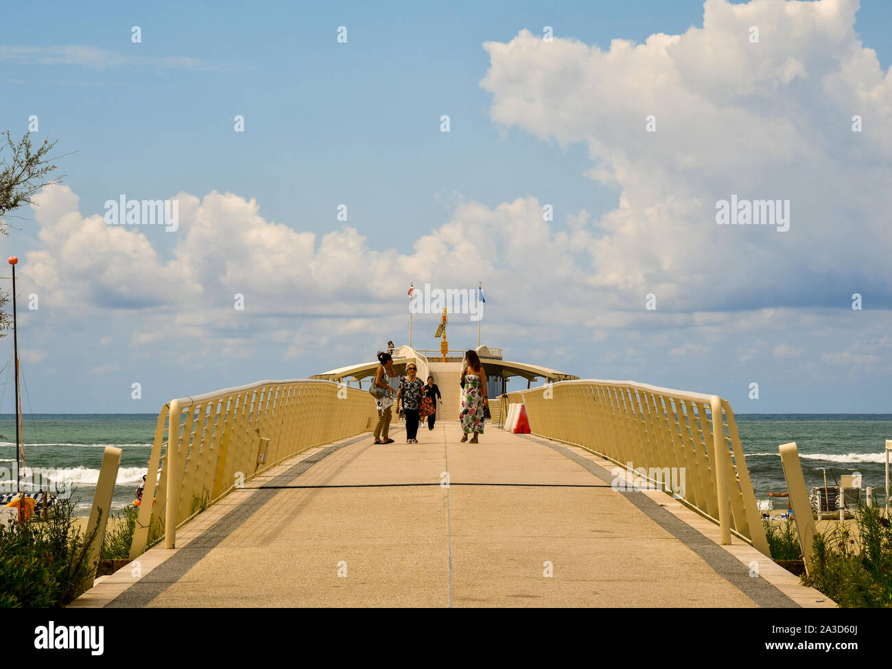 Un piccolo gruppo di donne di età diverse passeggiate sul molo moderno di Lido di Camaiore in una posizione soleggiata a metà agosto giorno, Versilia, Toscana, Italia Foto Stock