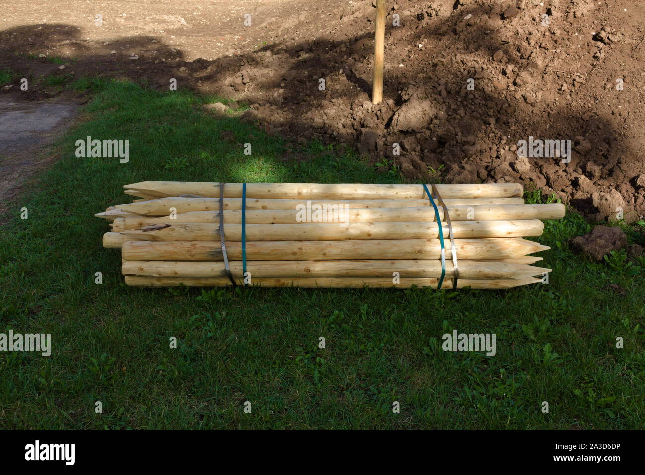 Sito in costruzione con pali in legno essendo tenute insieme con bande metalliche Foto Stock