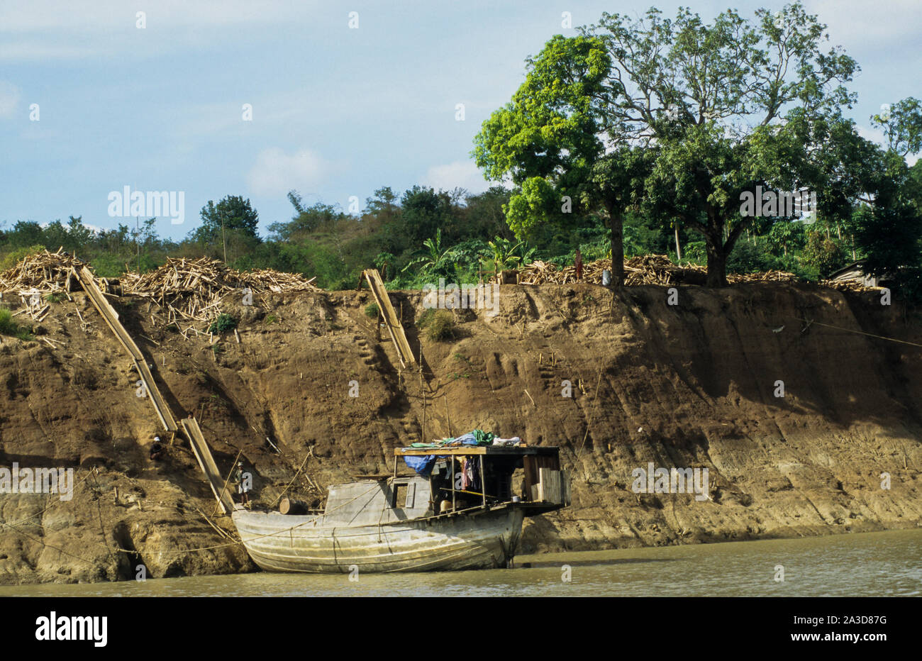 La Cambogia, il fiume Mekong, Kratie, la registrazione della foresta, il caricamento del legname sul fiume Mekong barche dalla rampa di scorrimento Foto Stock