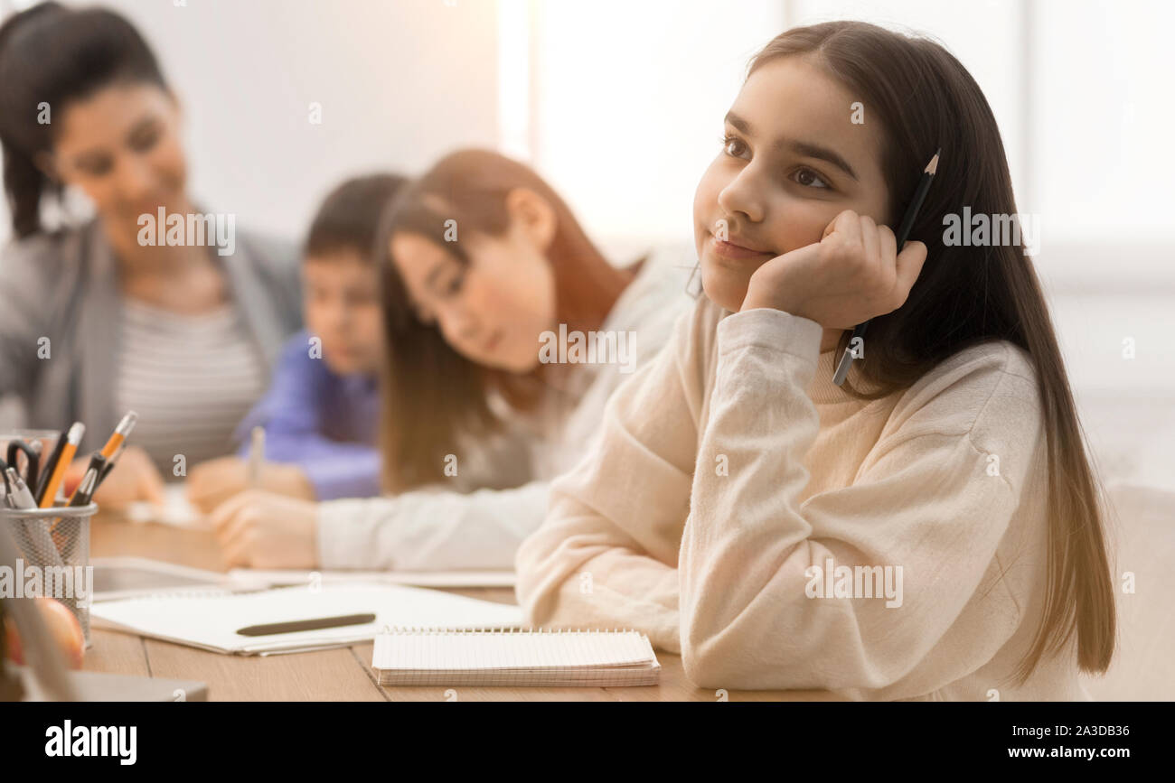 Felice ragazza fantasticando, seduti a lezione in aula Foto Stock