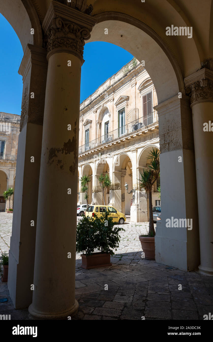 Vista attraverso arch al cortile del Palazzo del Governo (Palazzo del Governo) nel vecchio convento Celestino in Lecce, Puglia (Puglia), Italia Meridionale Foto Stock
