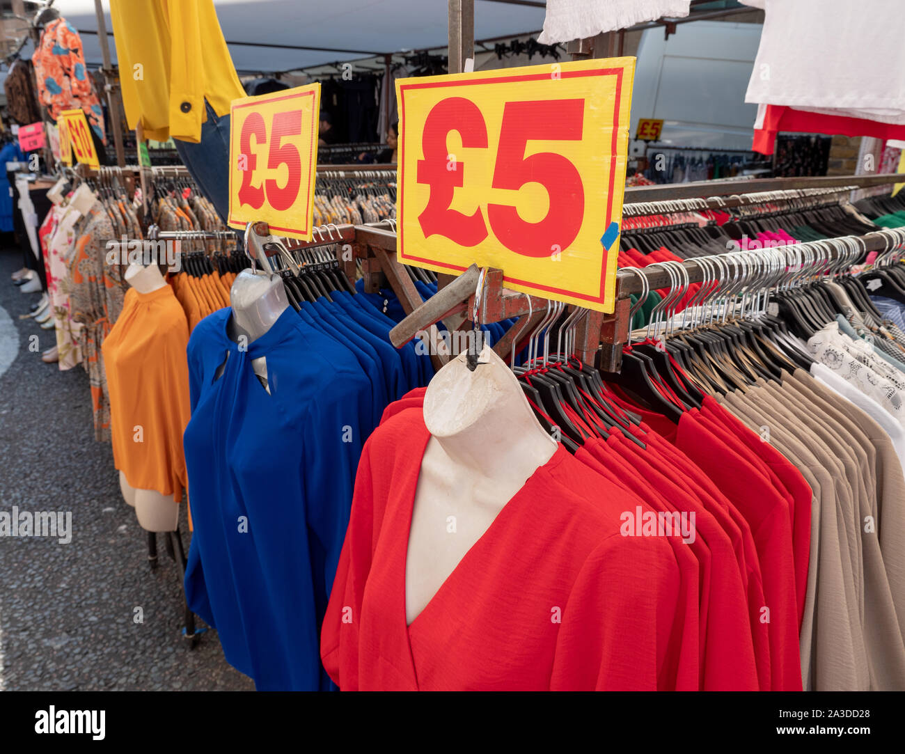 A buon mercato vestiti per la vendita in stallo a Petticoat Lane market Foto Stock