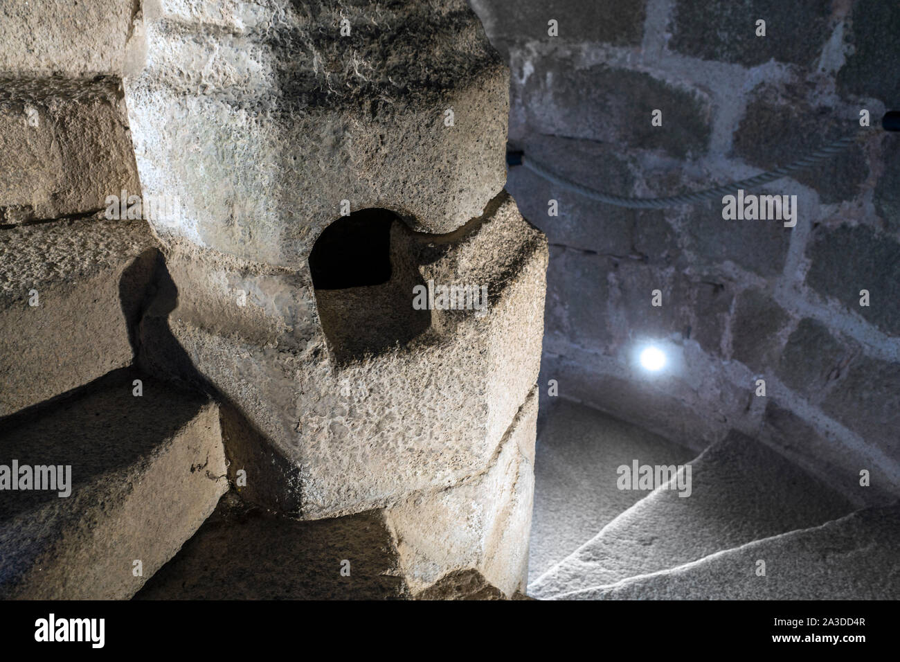 Pietra scalinata a spirale / avvolgimento scale con newel cava che è servita come fonte di luce in Château de Tiffauges, il castello medievale, della Vandea, Francia Foto Stock