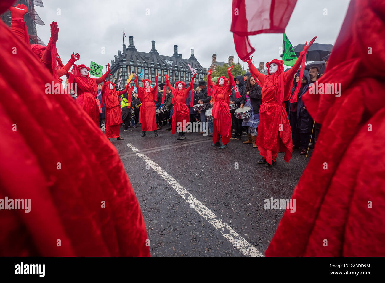 Londra, Regno Unito. Il 7 ottobre 2019. XR "Brigate Rosse Mimi' in rosso sangue e accappatoi sul Westminster Bridge. La Ribellione di estinzione cominciare la ribellione internazionale occupando siti a undici sedi al di fuori dei ministeri, Downing St, il Mall, Westminster e ponti di Lambeth, portando il traffico ad un arresto. Essi richiedono che il governo dica la verità circa il clima e l'emergenza ecologica, atto ad arrestare la perdita di biodiversità, emissioni ridotte a zero netto e di creare e di essere guidato da un gruppo di cittadini. Peter Marshall / Alamy Live News Foto Stock