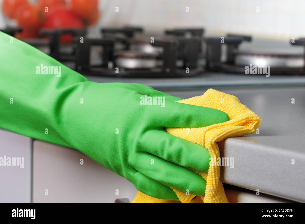Close-up di una mano in un guanto protettivo tenendo un rag. La pulizia della cucina. Foto Stock