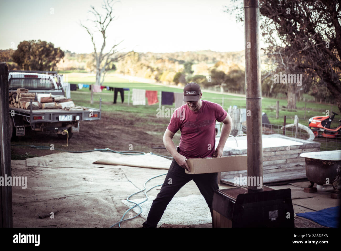 Maschio giovane agricoltore con tappo funziona su australian farm capannone Foto Stock