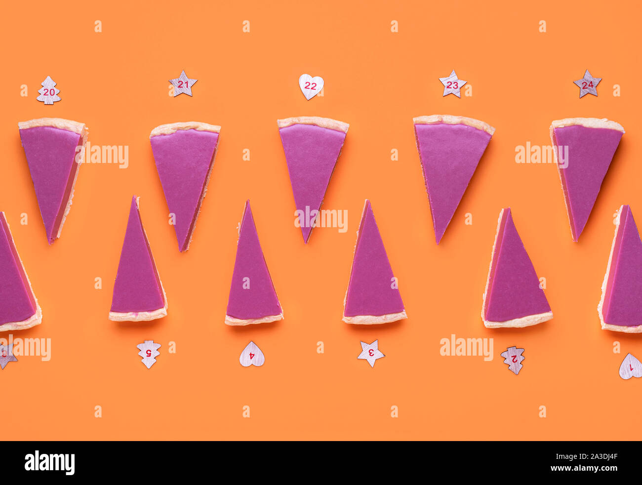 Natale calendario dell'Avvento con cioccolato rubino fette di torta e i numeri su sfondo arancione. Rosa fette di torta pattern. Dolce di Natale sfondo. Foto Stock