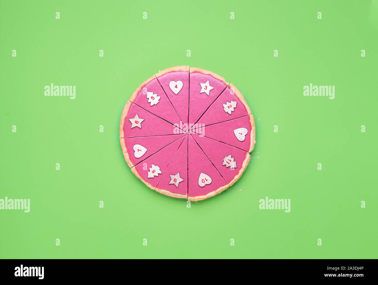 Avvento natale contesto con una rosa di cioccolato fette di torta con i numeri su di esso. Torta al cioccolato sul tavolo verde. Numerate da fette di torta. Limitato di pezzi di torta. Foto Stock