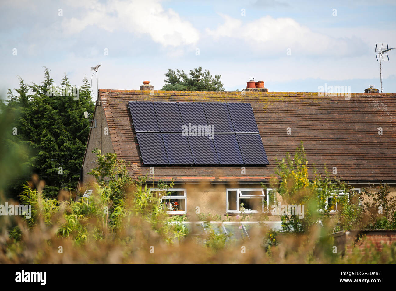 Una casa rurale che ha avuto i pannelli solari installati sul tetto per generare energie pulite di energia verde Foto Stock