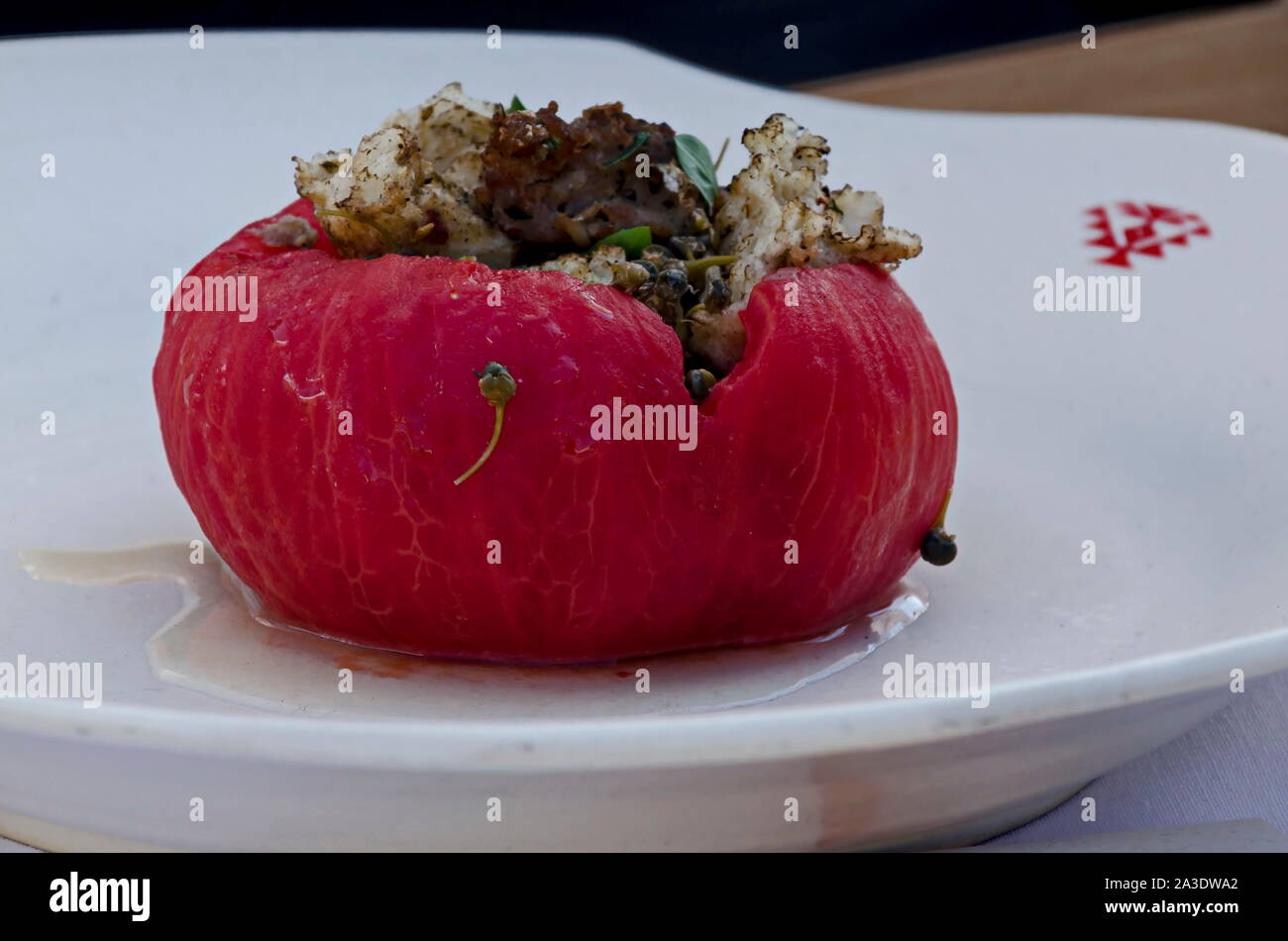 Una specialità di ripe rosa pelati pomodori ripieni con prosciutto e formaggio, panna e spezie preparato in un forno, Sofia, Bulgaria Foto Stock